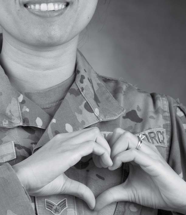 Airmen in uniform making a heart sign with hands